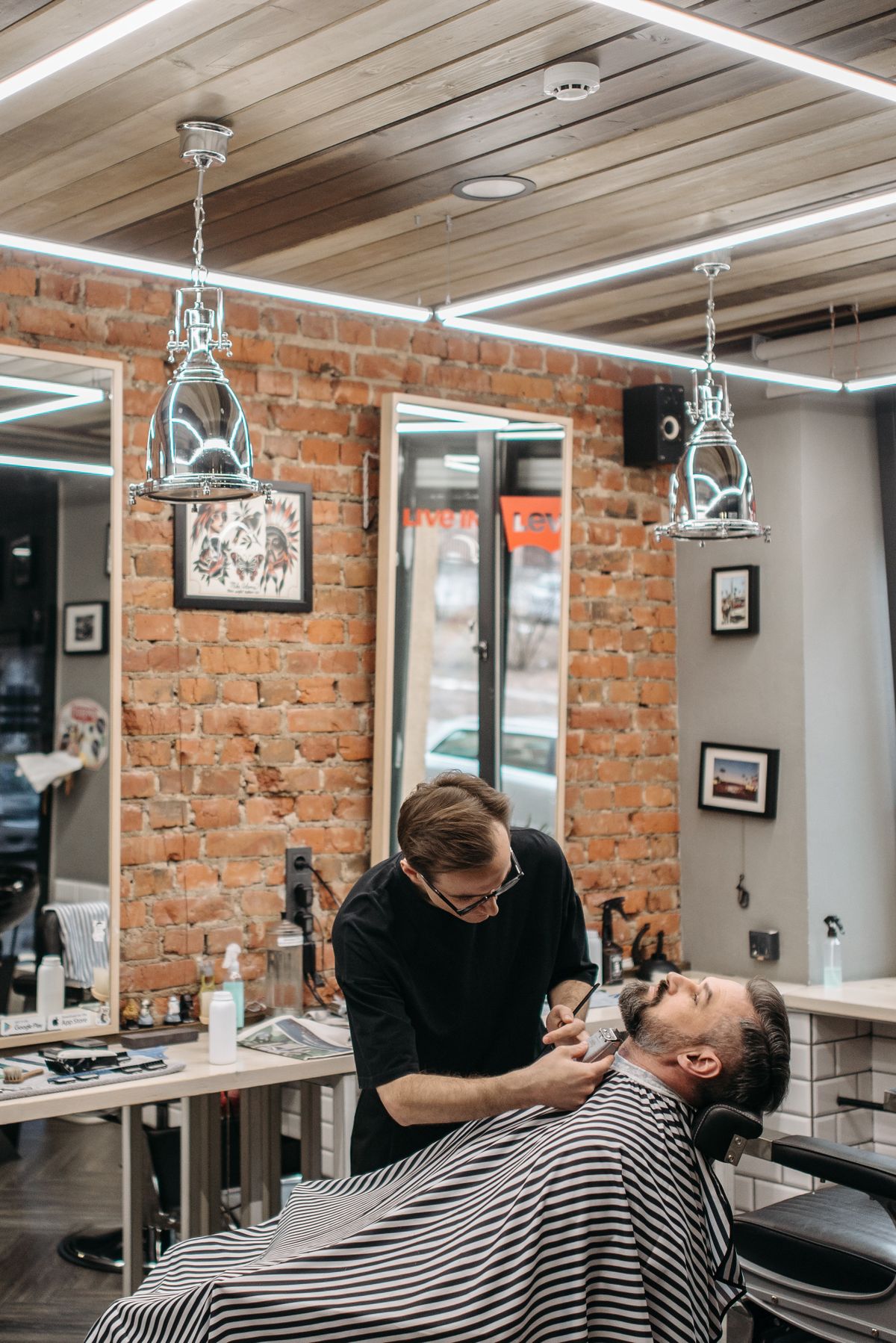 Barber περιποιείται τη γενειάδα άνδρα σε ανακλινόμενη καρέκλα